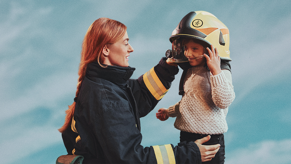 Firefighter putting helmet on child