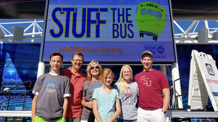 group of people in front of Stuff the bus sign